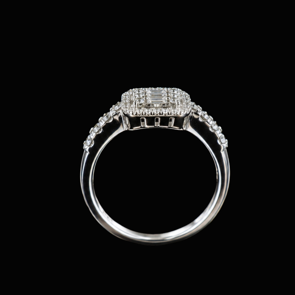 A silver ring with a central emerald-cut CZ stone and smaller round CZ stones, set in a delicate silver band.