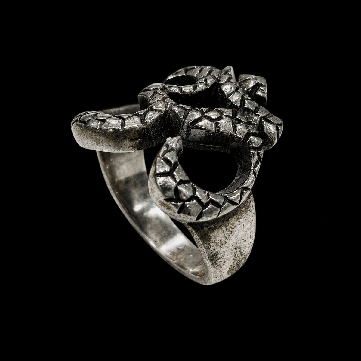 A silver ring with intricate enamel work, featuring a unique design.