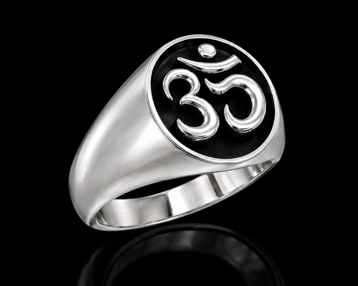A silver ring with the Om symbol on it, set against a plain background.
