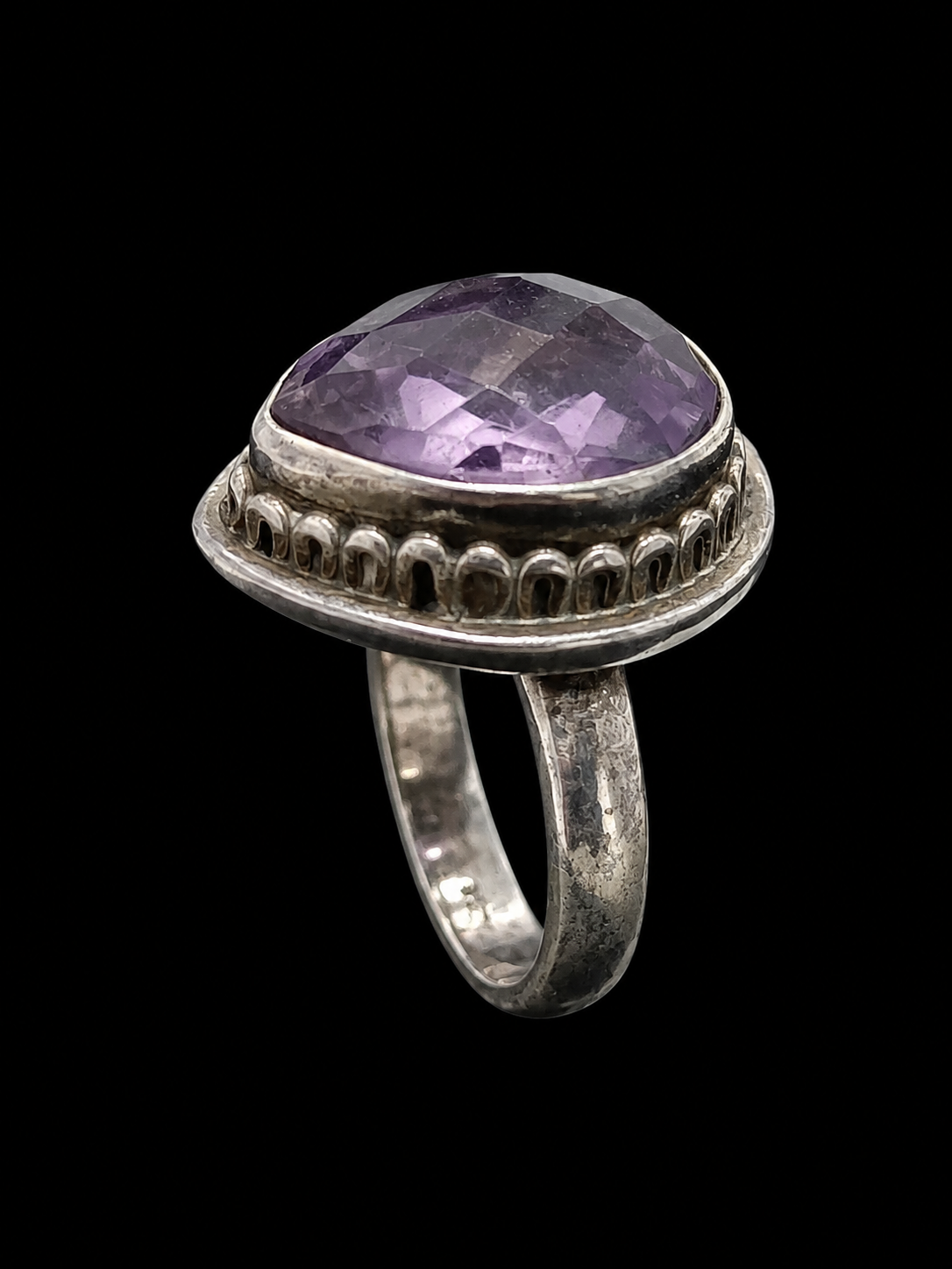 A silver-tone ring with a large, faceted purple CZ stone.