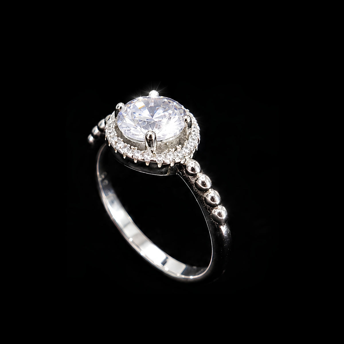 A silver-tone ring with a round-cut clear cubic zirconia stone and smaller stones around it.
