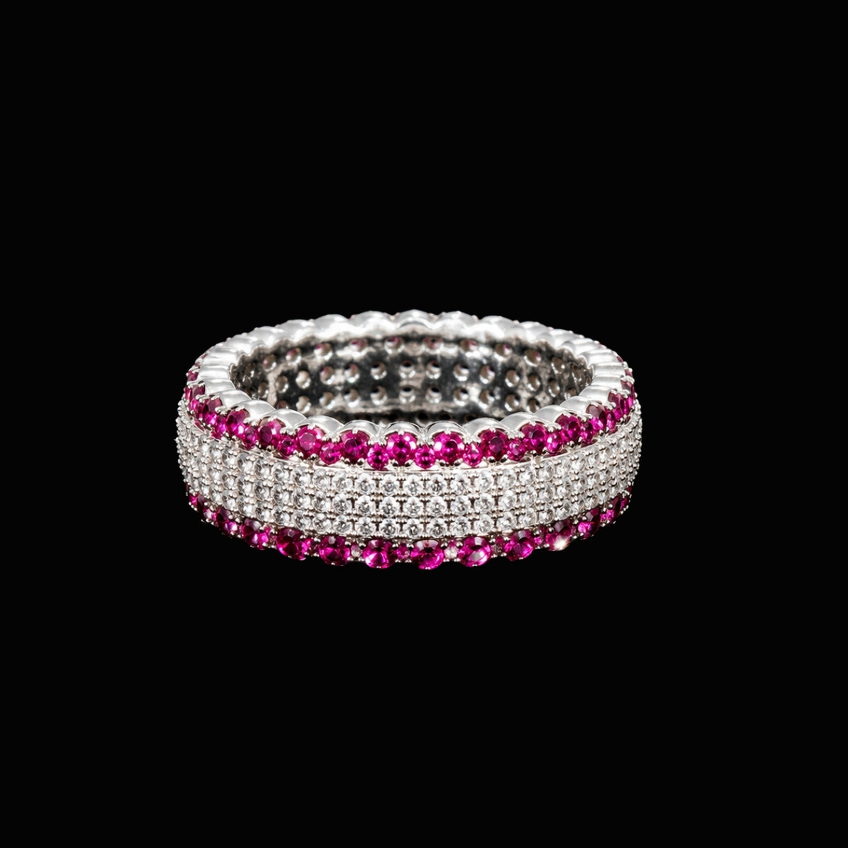 A silver-tone ring with clear cubic zirconia and pink rubies set in a classic band design.