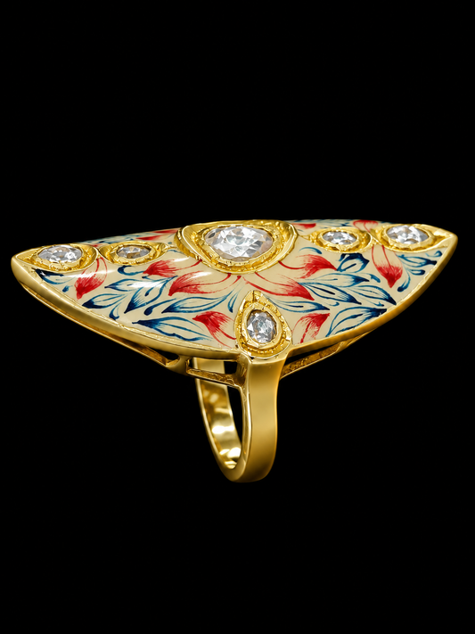 A gold ring with a triangular design and red and blue enamel work, featuring clear CZ stones.