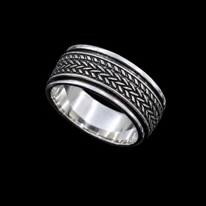 A silver band ring with intricate enamel work and a simple closure.