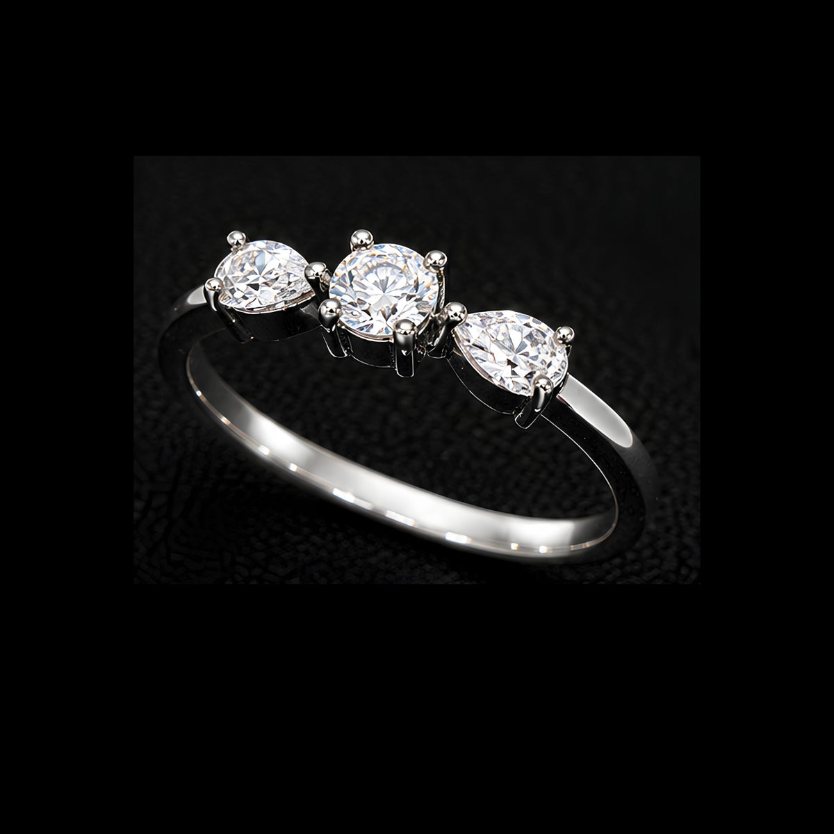 A silver-tone ring with three round-cut cubic zirconia stones set in a minimalist design.