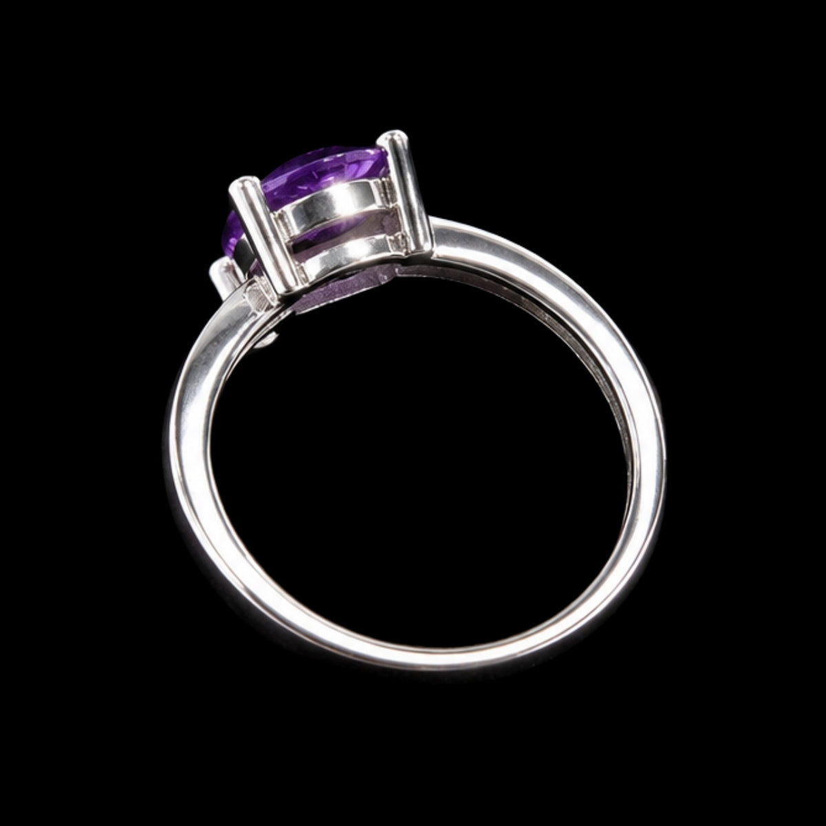 A silver ring with a round-cut amethyst stone, set in a simple design.