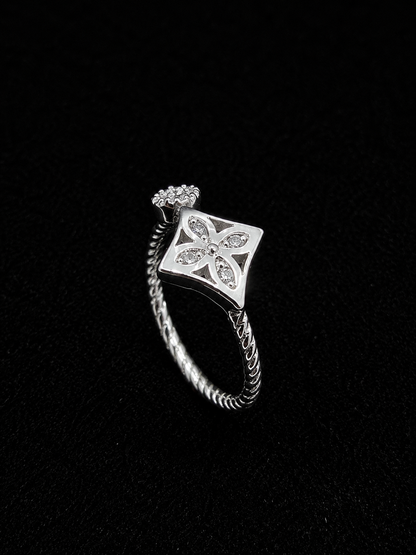 A silver ring with a square design and clear cubic zirconia stones.