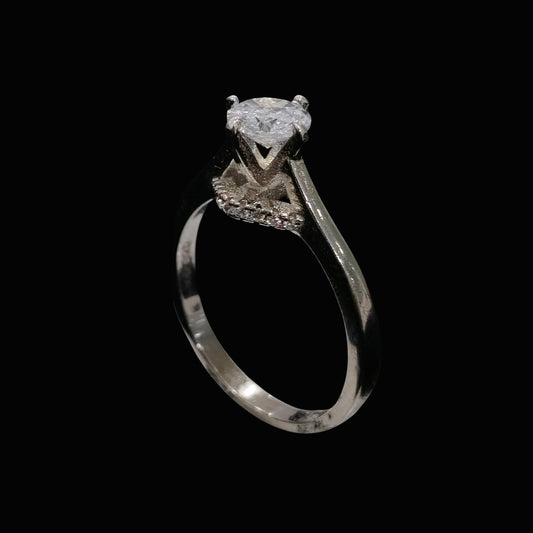 A silver ring with a large clear cubic zirconia stone on a black background.