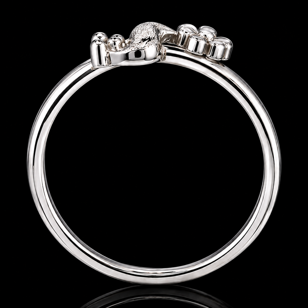 A silver ring with a lion's head motif on a black background