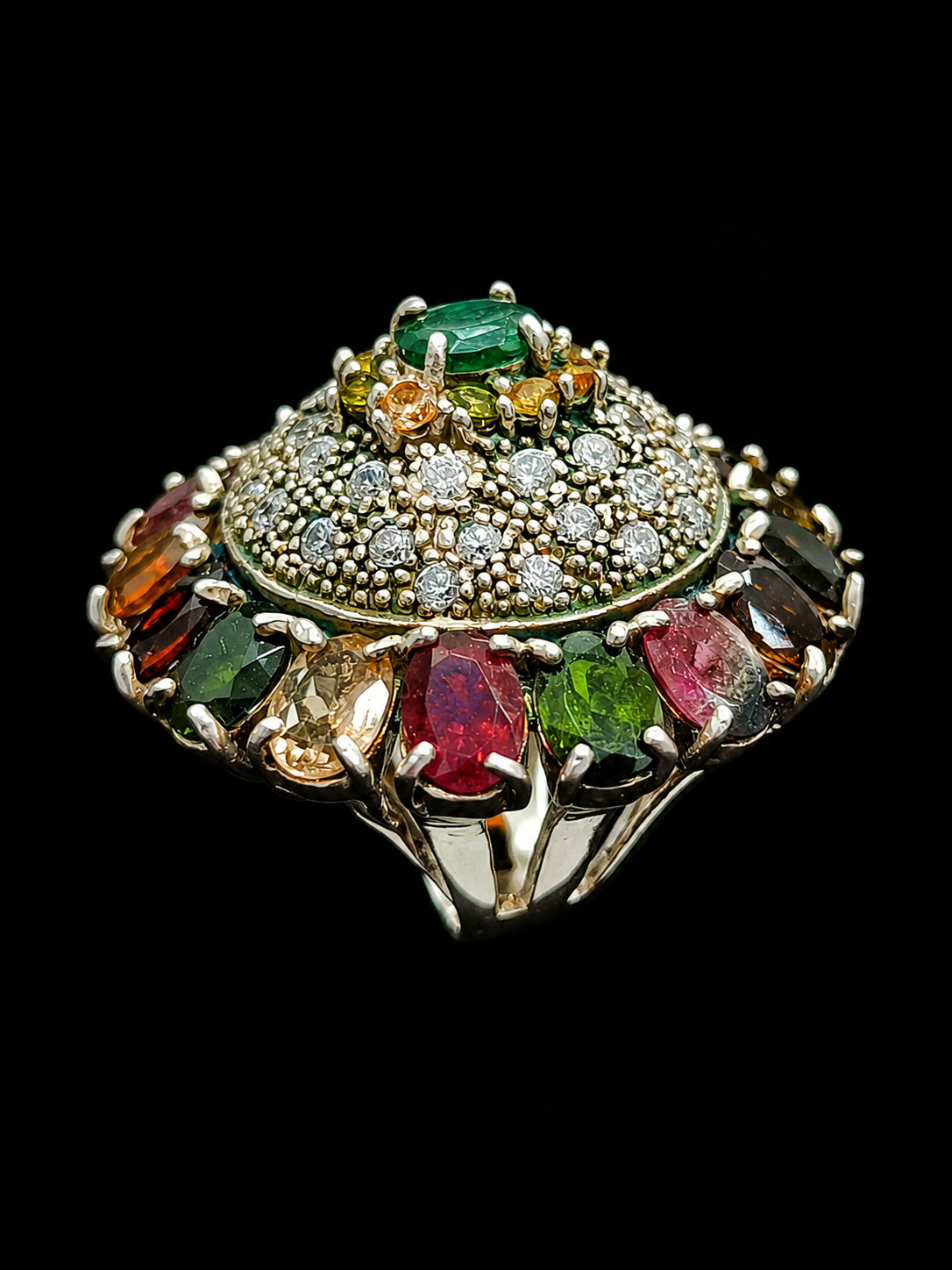 A silver ring with an enamel design and CZ stones.