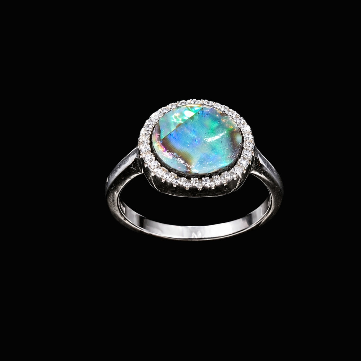 A silver ring with a round opal stone and CZ accents