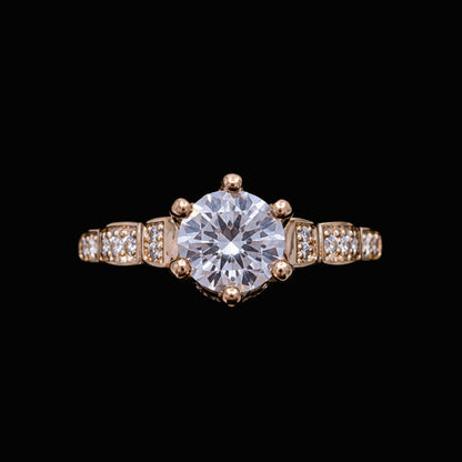 A gold-tone ring with a large round-cut CZ stone and smaller CZ stones on a delicate gold-tone band.