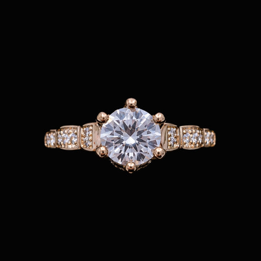 A gold-tone ring with a large round-cut CZ stone and smaller CZ stones on a delicate gold-tone band.