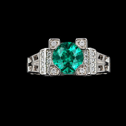 A silver ring with an emerald green CZ stone and clear CZ accents, set in an Art Deco-inspired geometric design.