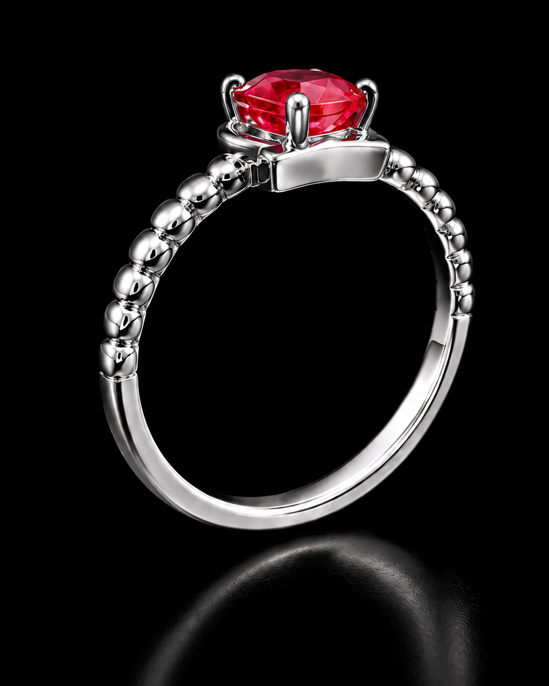 A silver ring with a red gemstone on a black background.