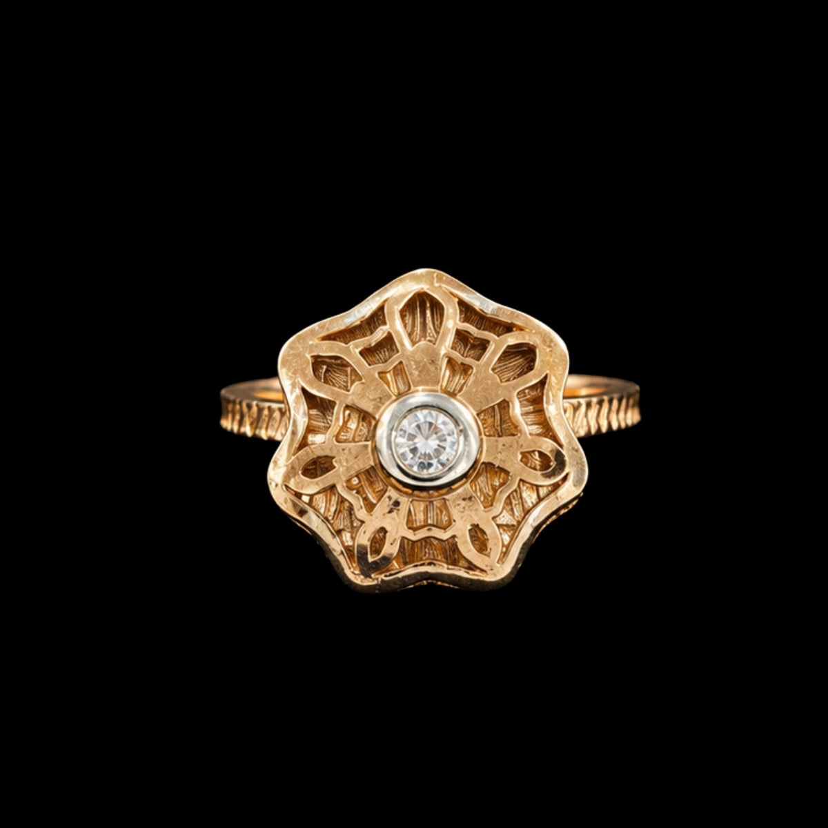 A gold-tone ring with a CZ stone in the center, surrounded by an intricate floral design.