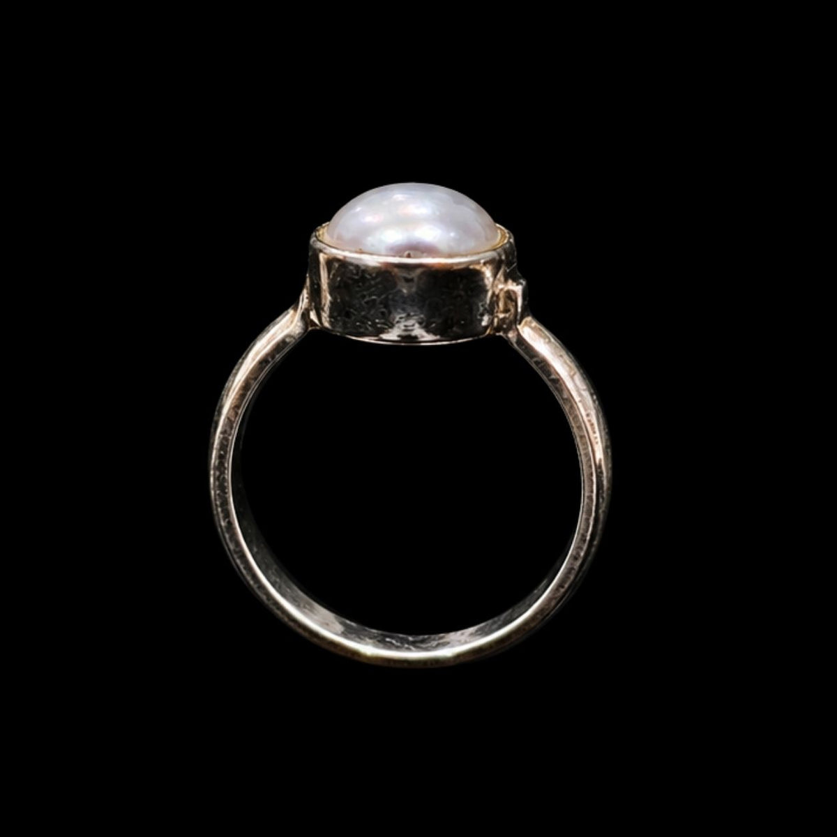 A silver ring with a round pearl on a black background.