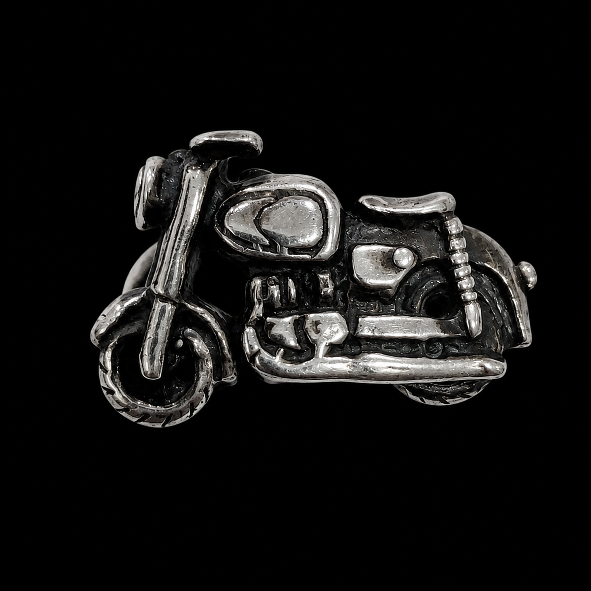 A silver ring with a detailed motorcycle design
