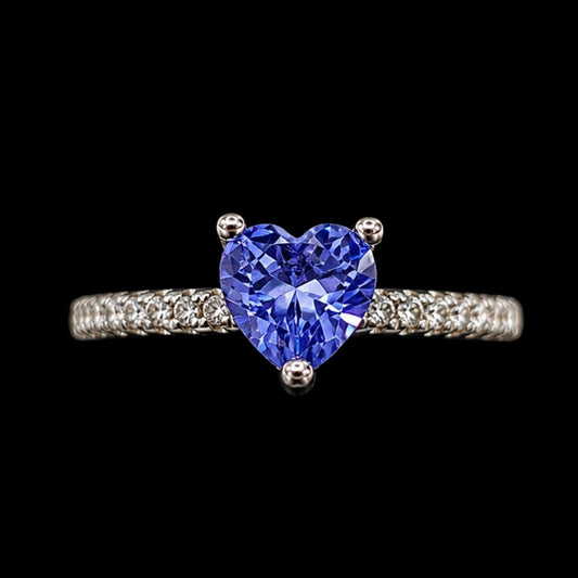 A silver ring with a heart-shaped tanzanite stone, set on a silver band.