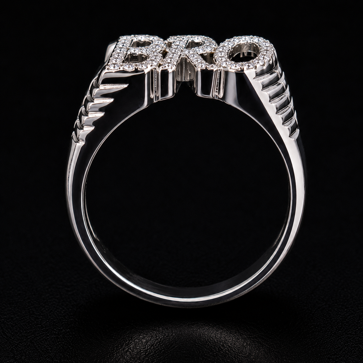 A silver ring with the word "PRO" in block letters, set with clear cubic zirconia stones.