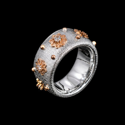 A gold and silver tone ring with CZ stones on a textured silver-tone band.