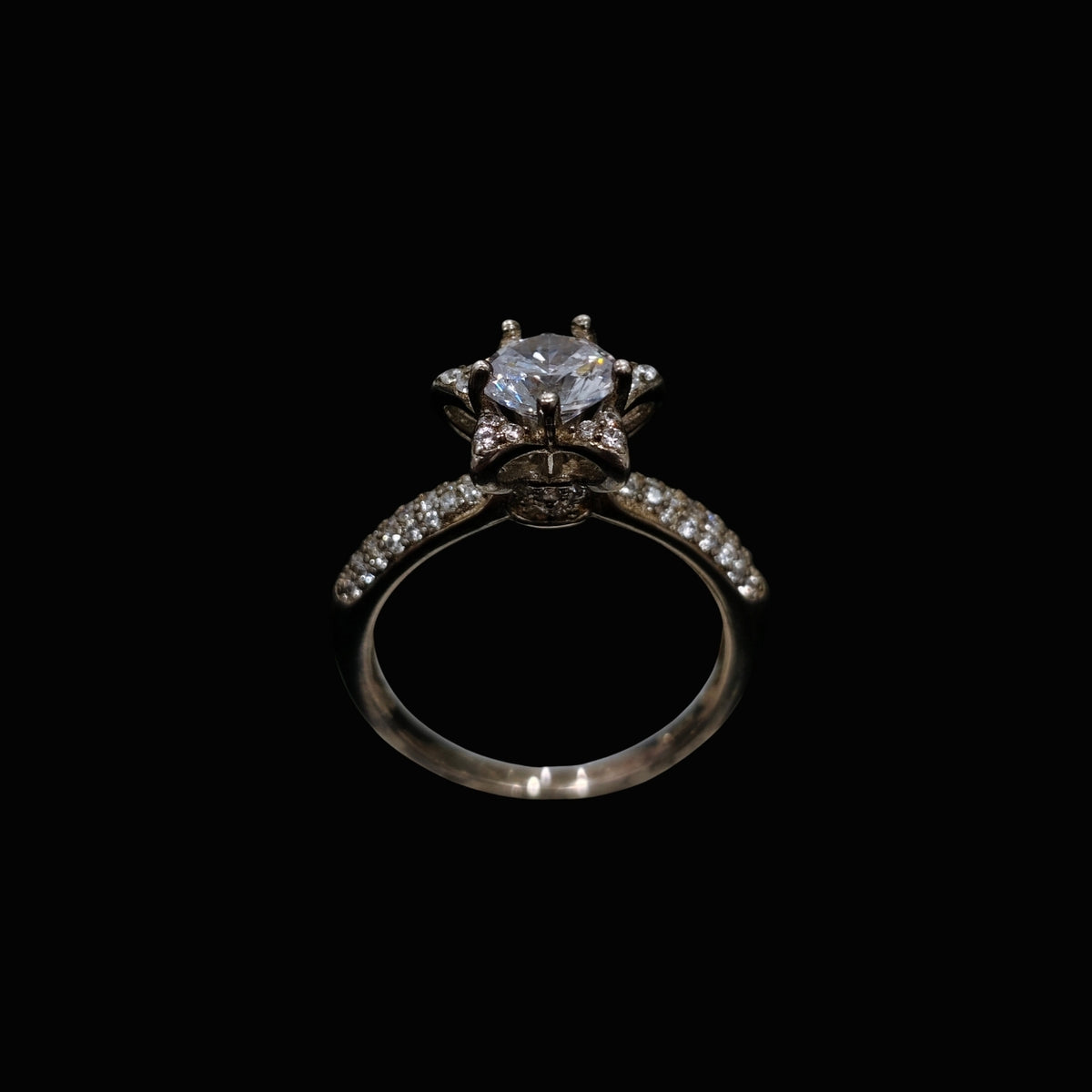 A silver ring with a large clear CZ stone and smaller stones on the band.