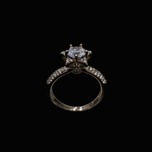 A silver ring with a large clear CZ stone and smaller stones on the band.