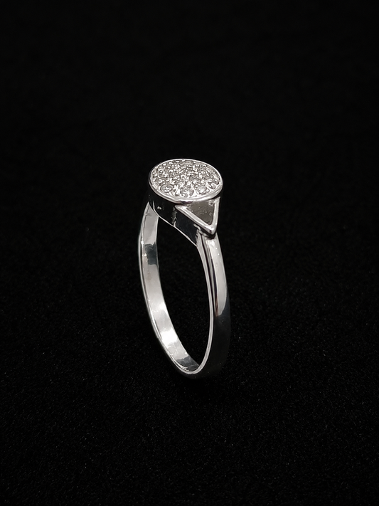 A silver ring with a round CZ stone setting, on a black background.