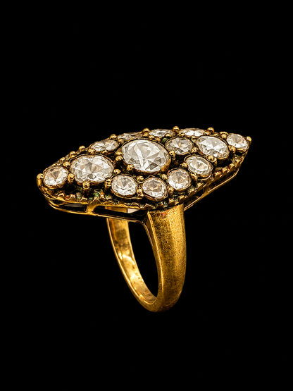 A gold-tone ring with a geometric design and clear CZ stones.