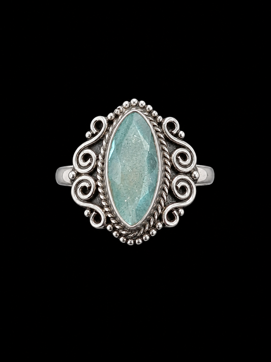 A silver ring with an aquamarine stone set in a delicate setting.
