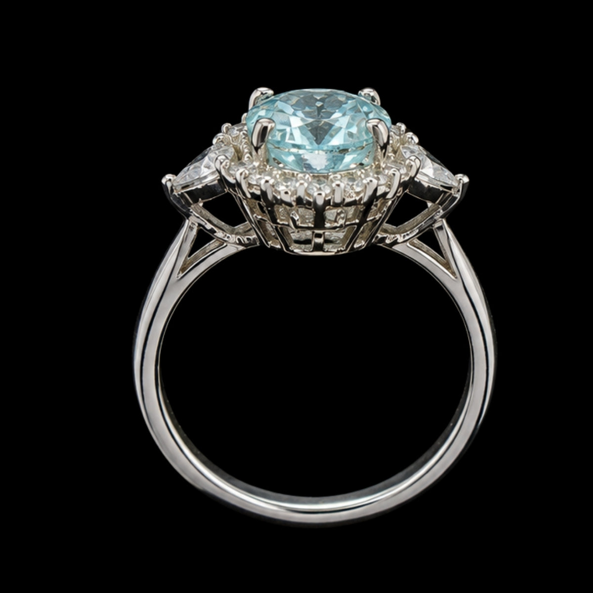 A silver-tone ring with a large blue gemstone and smaller clear gemstones, set in a delicate floral design.