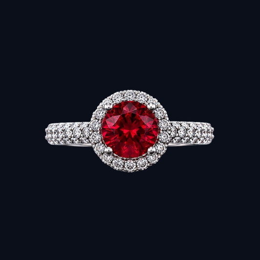 A silver ring with a ruby at its center, surrounded by a halo of sparkling CZ stones.
