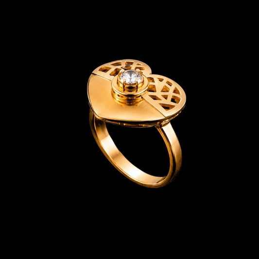 A gold-tone ring with a round CZ stone and a geometric design.