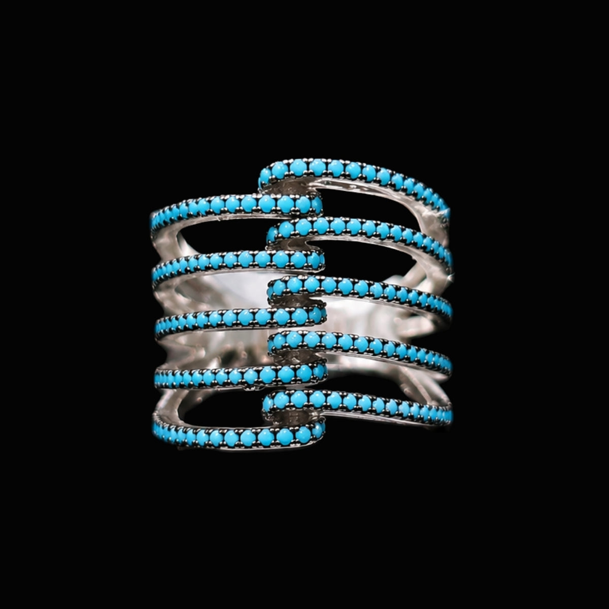 A silver-tone ring with a spiral design and turquoise stones.