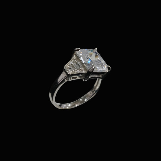 A silver ring with a large, clear cubic zirconia stone and smaller stones set in a modern geometric design.