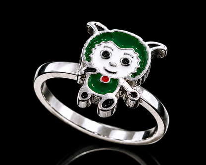 A silver-tone ring with a green girl design and red enamel accent.