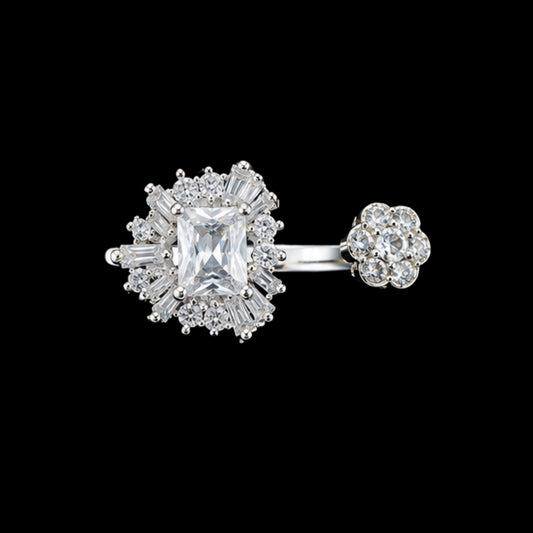 A silver ring with a large CZ stone and smaller stones in a floral design.