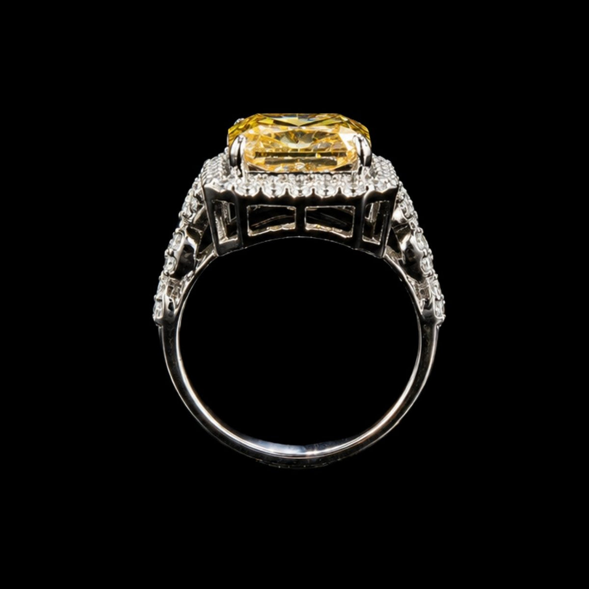 A silver ring with a large yellow CZ stone in the center, surrounded by a halo of smaller stones.
