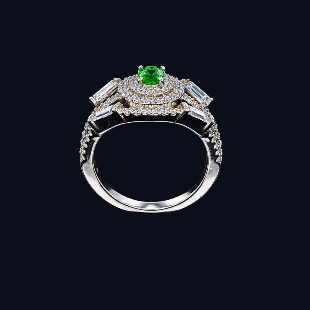 A silver ring with an emerald stone and CZ stones on a black background