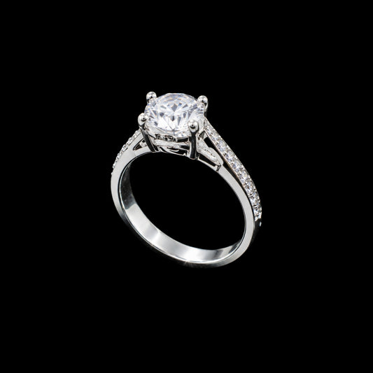 A silver-tone ring with a round-cut cubic zirconia stone and smaller stones on the band.