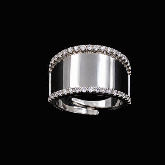 A silver ring with a wide band and round-cut CZ stones.