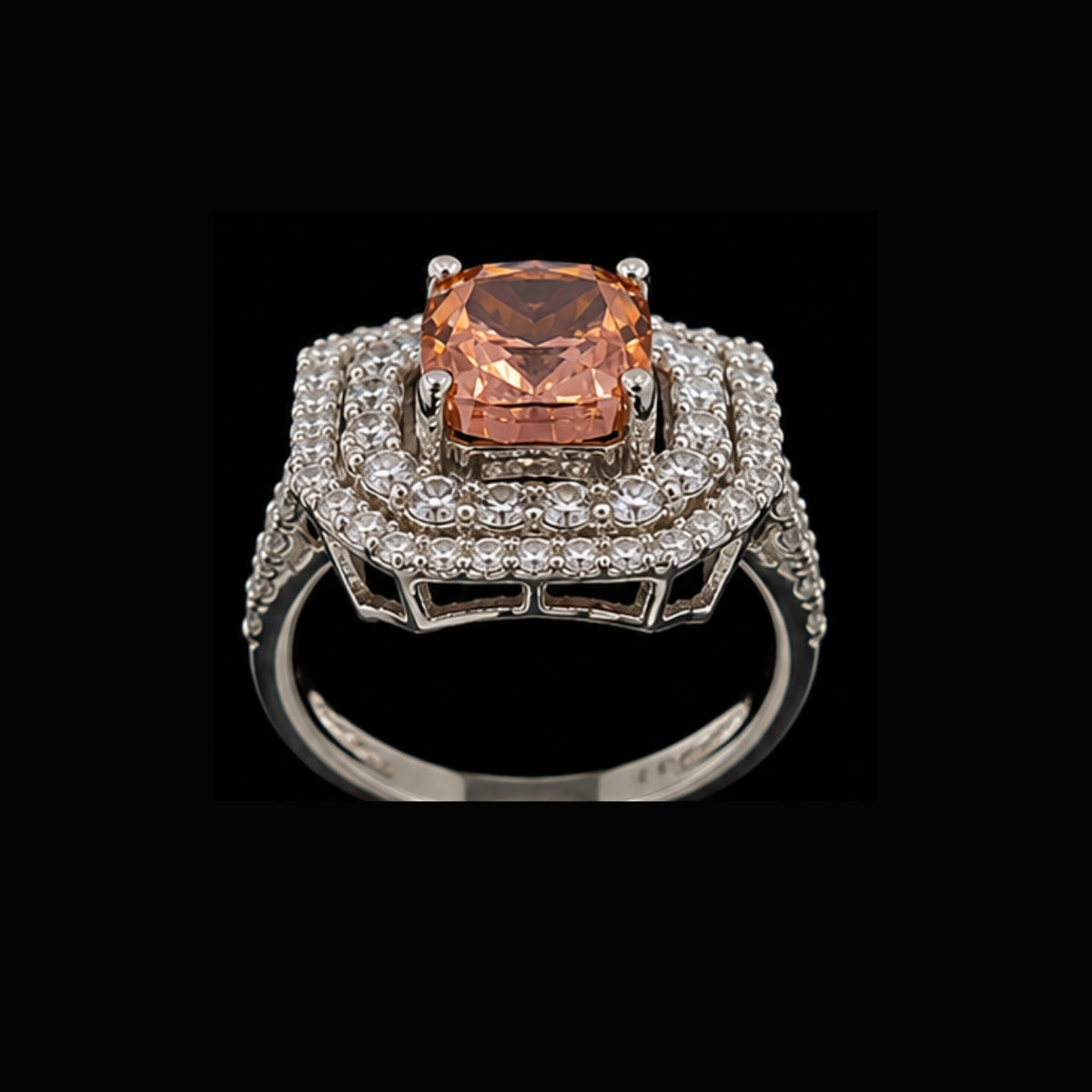 A silver-tone ring with a peach CZ stone and clear CZ halo on a black background.