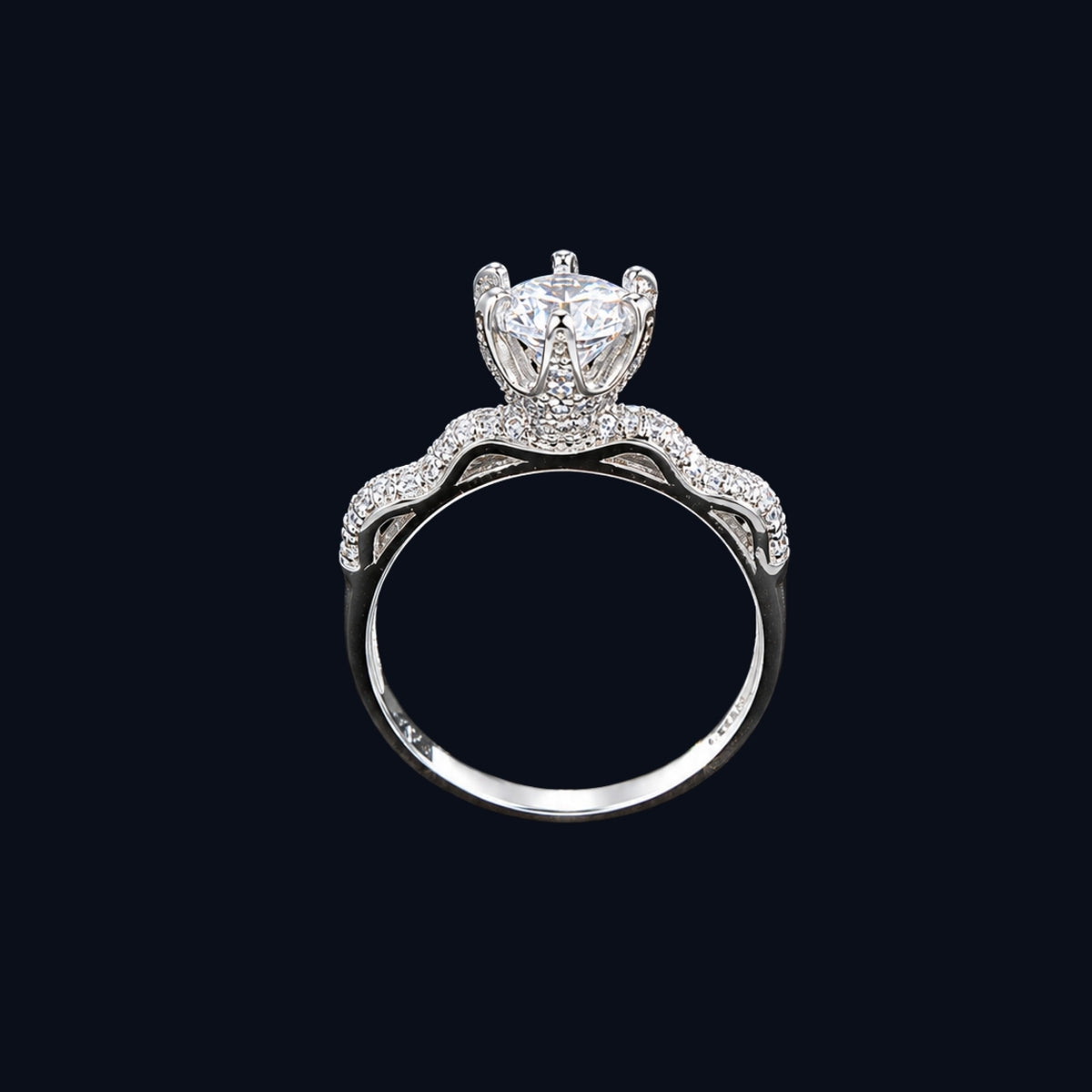 A crown ring with a large clear cubic zirconia stone and smaller stones set in silver-tone metal.