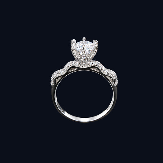 A crown ring with a large clear cubic zirconia stone and smaller stones set in silver-tone metal.