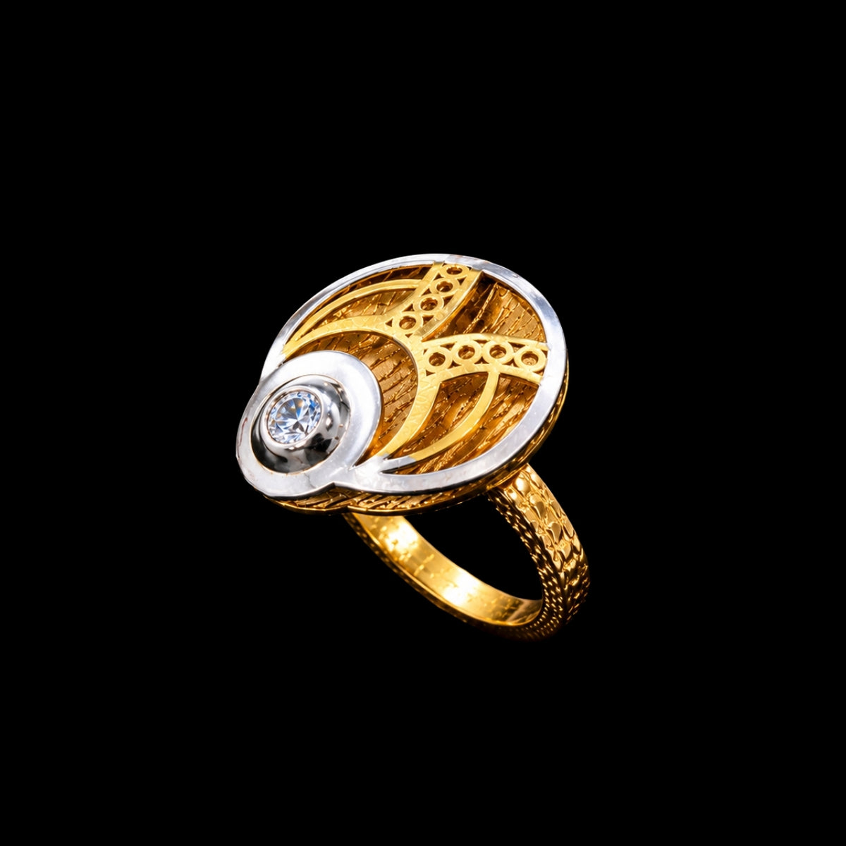 A gold and silver ring with a CZ stone, featuring a geometric design.