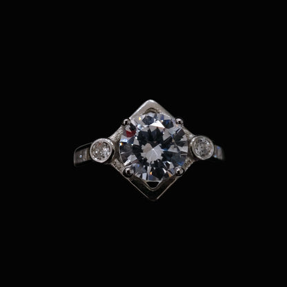 A silver ring with a large clear CZ stone and two smaller stones on either side.
