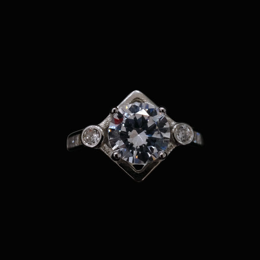 A silver ring with a large clear CZ stone and two smaller stones on either side.