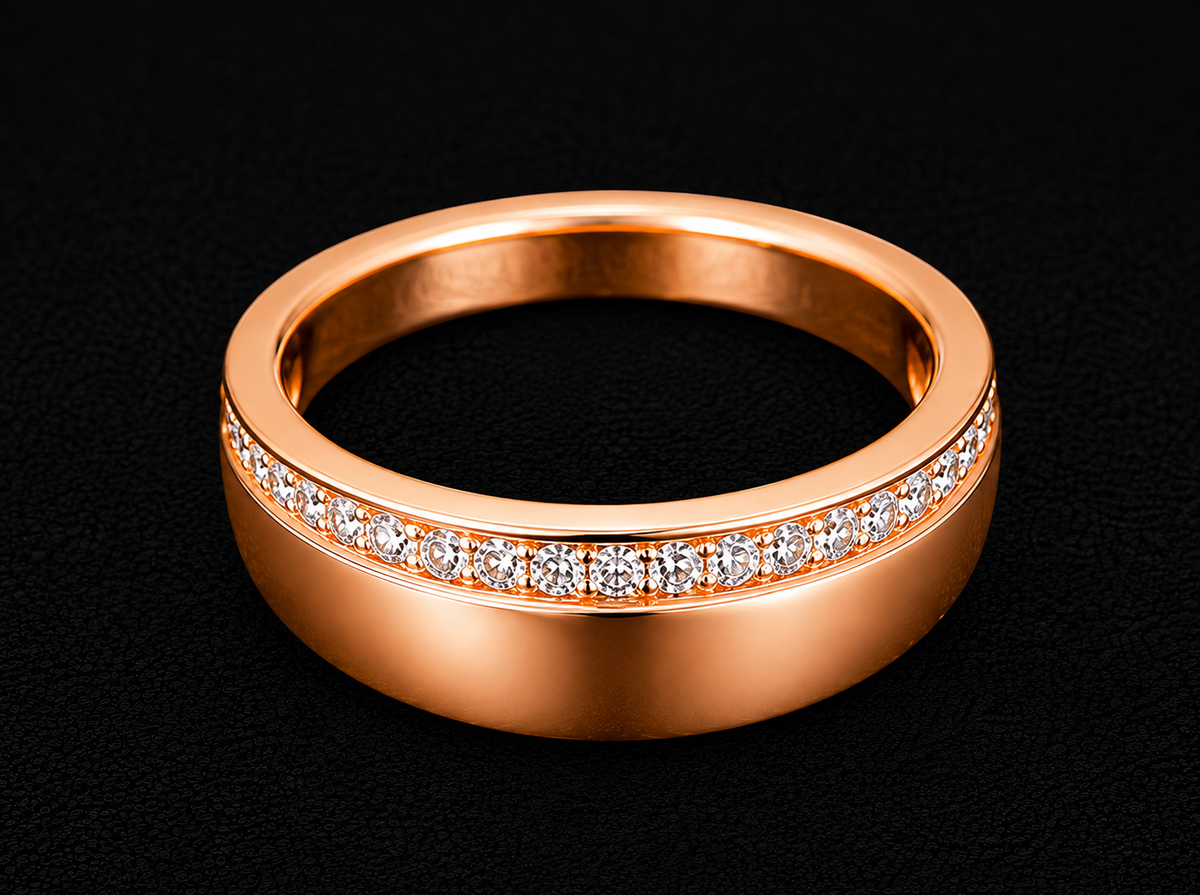 A rose gold band with a row of cubic zirconia stones along its top edge.