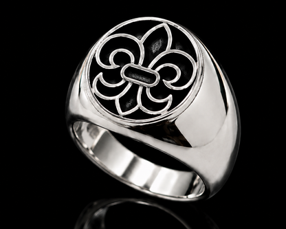 A silver ring with a fleur-de-lis design on a black background