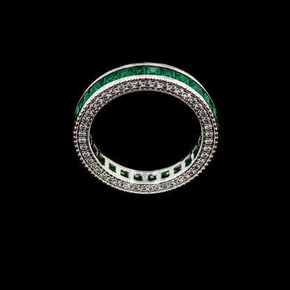 A silver-tone ring with a double row of emerald green and clear CZ stones.